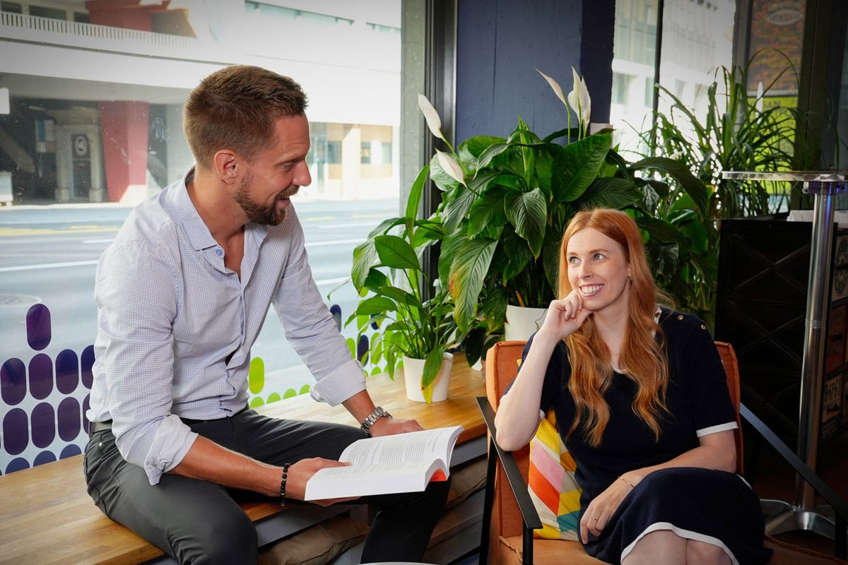 Sina und Kai sitzen nebeneinander an einem Tisch